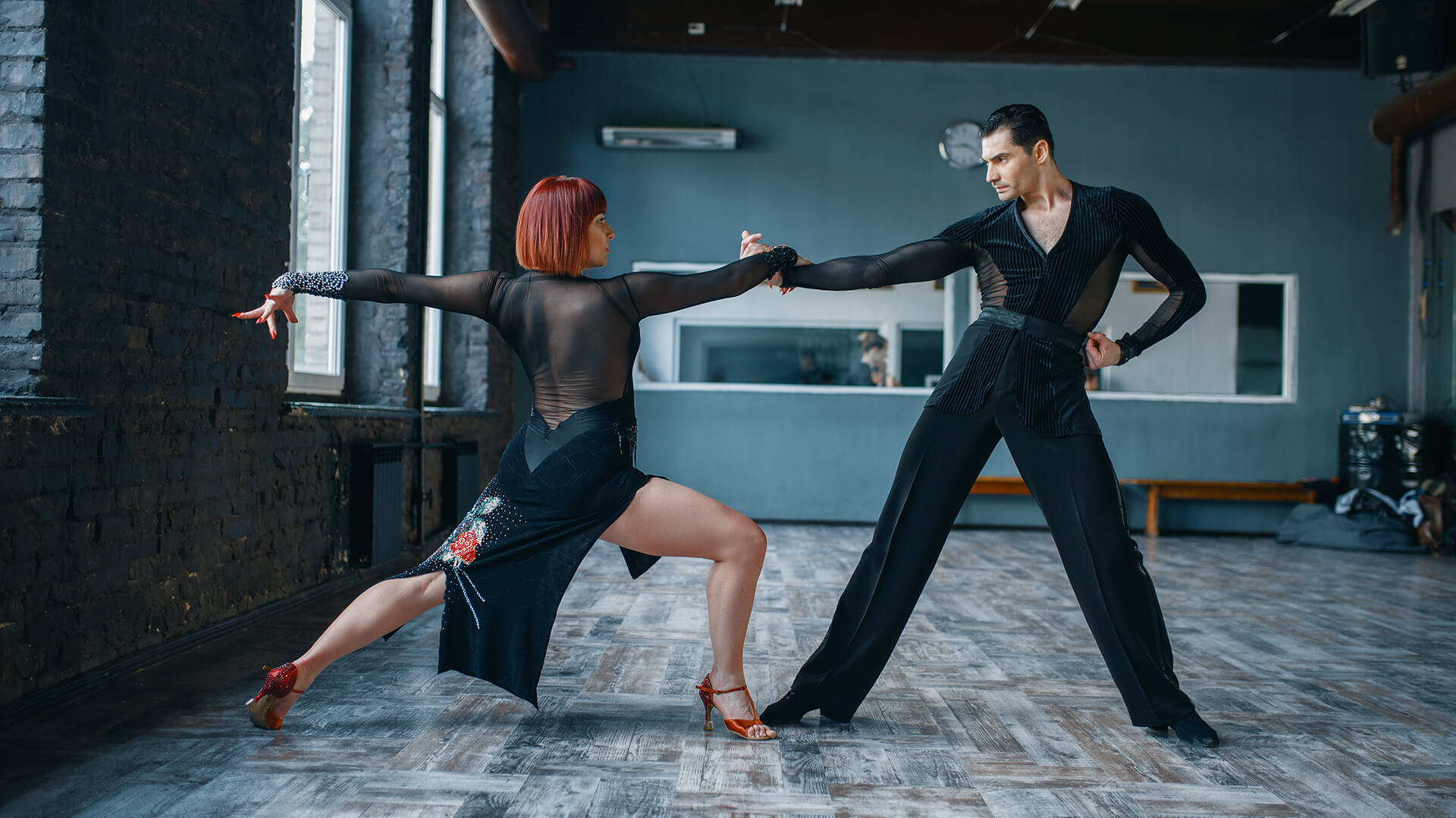 Ζευγάρι ενηλίκων εκτελεί χορευτική φιγούρα λάτιν σε στούντιο χορού.